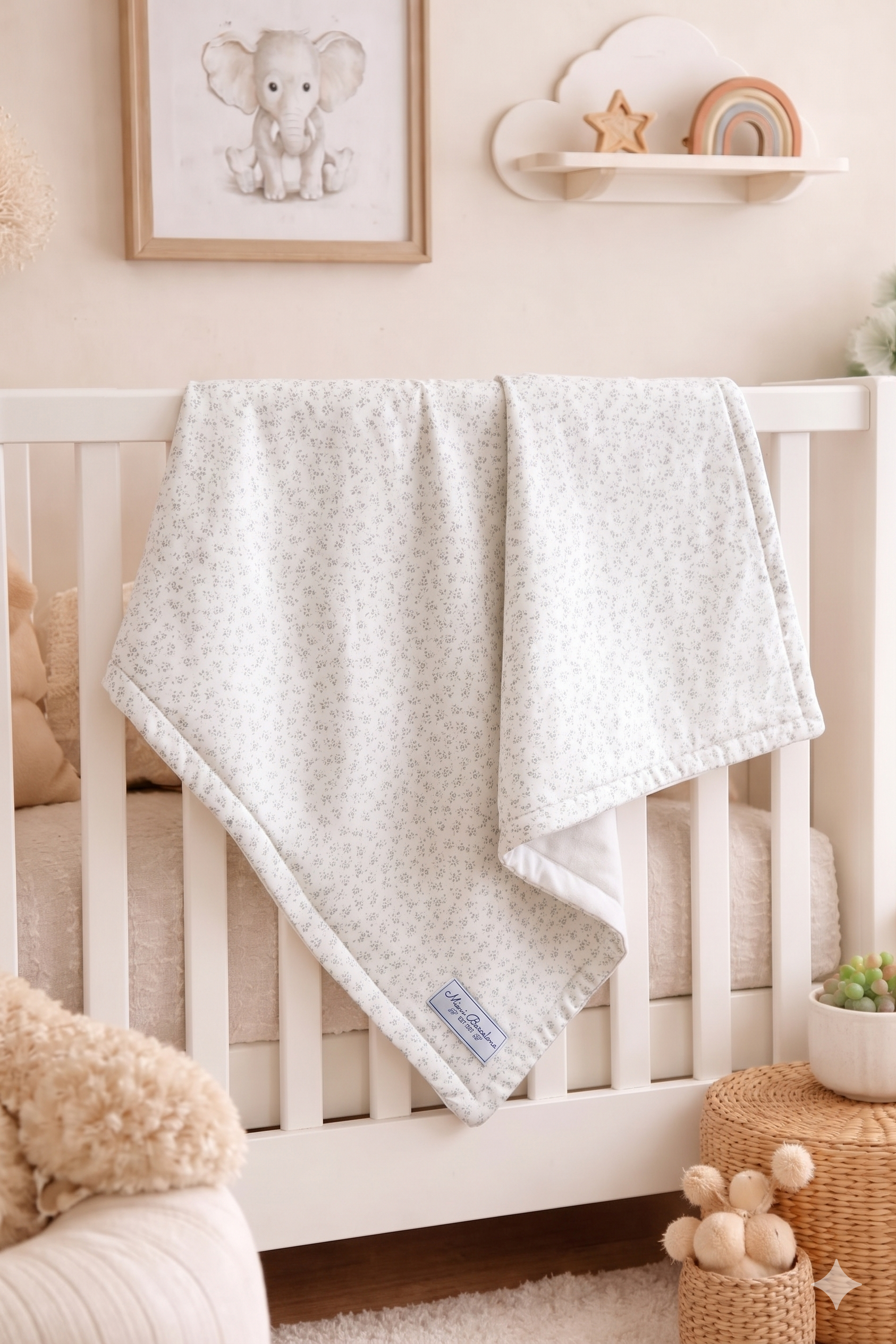 White crib with a textured blanket draped over it in a nursery setting.