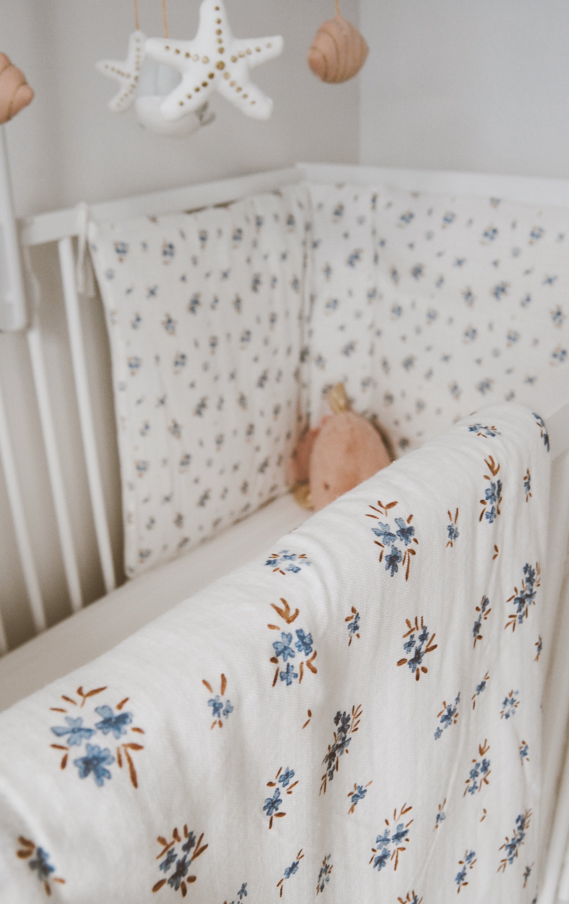 baby blanket and cot bumper in a nursery