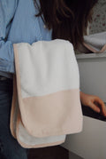 A pink face cloth with a dotted white print, folded neatly.