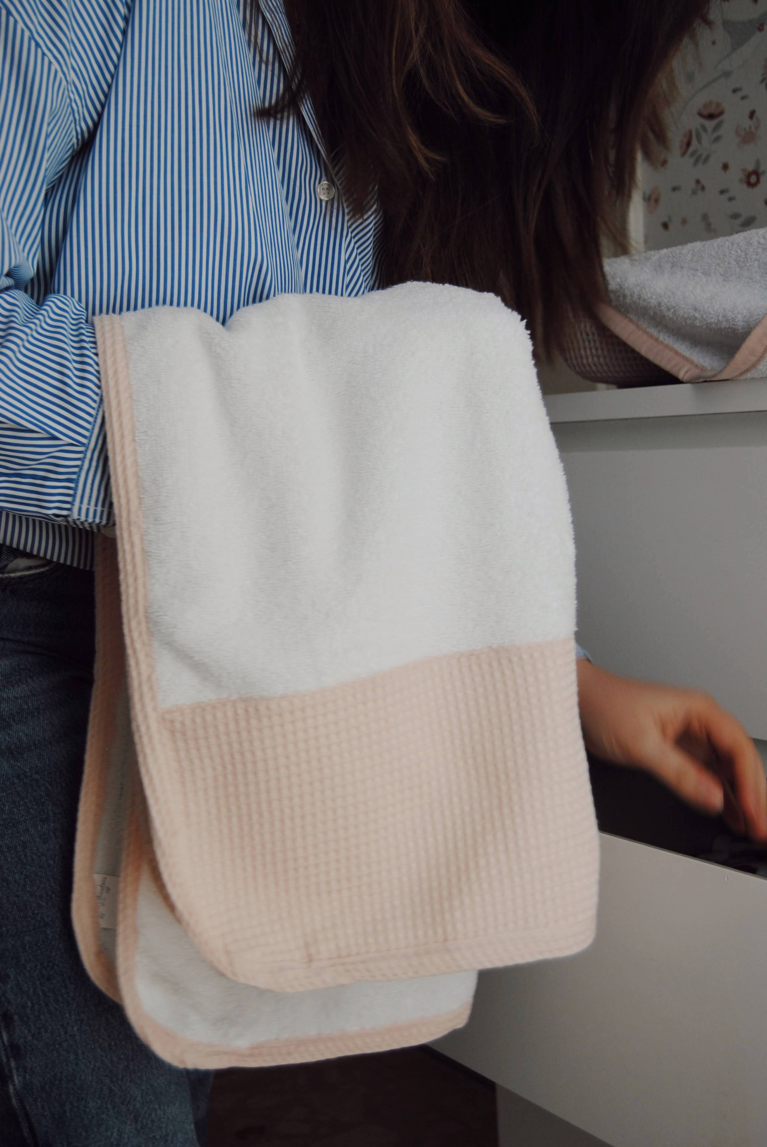 A pink face cloth with a dotted white print, folded neatly.